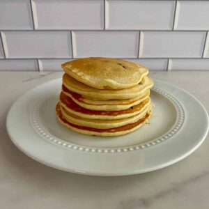 A plate with a stack of Chocolate Chip Pancakes.