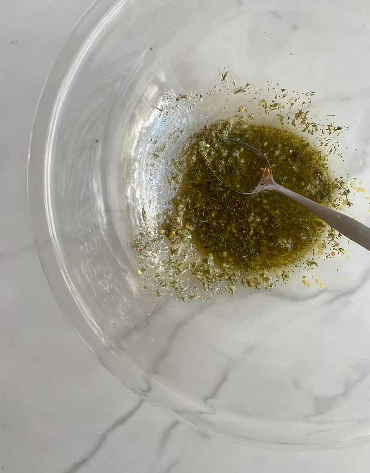 Bowl with oil, garlic and spices for Greek Chicken.