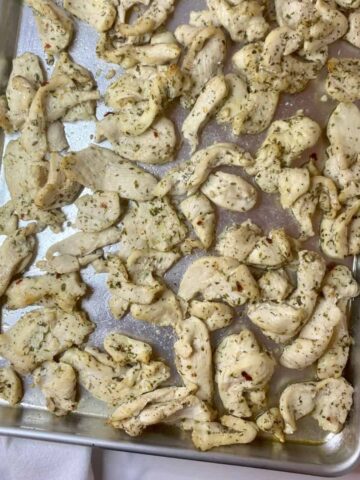 Sheet pan with cooked Mediterranean Chicken Tray Bake.