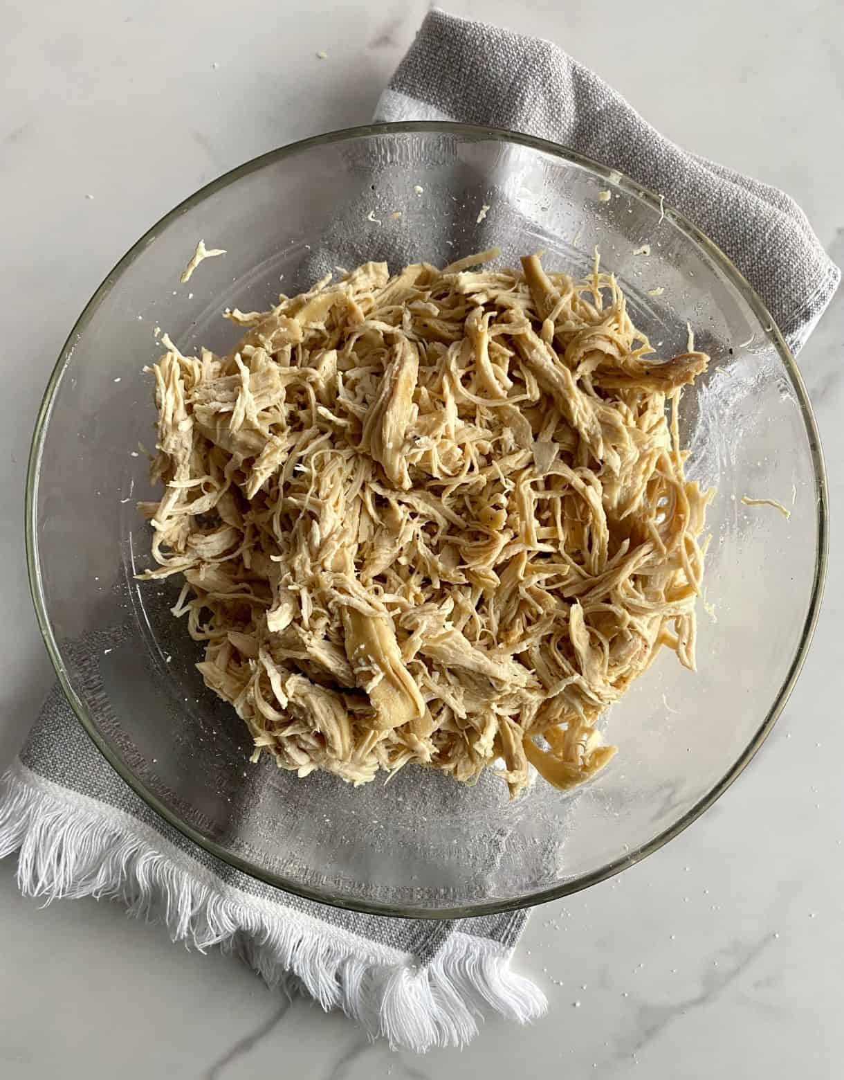 A bowl of cooked shredded chicken breast.