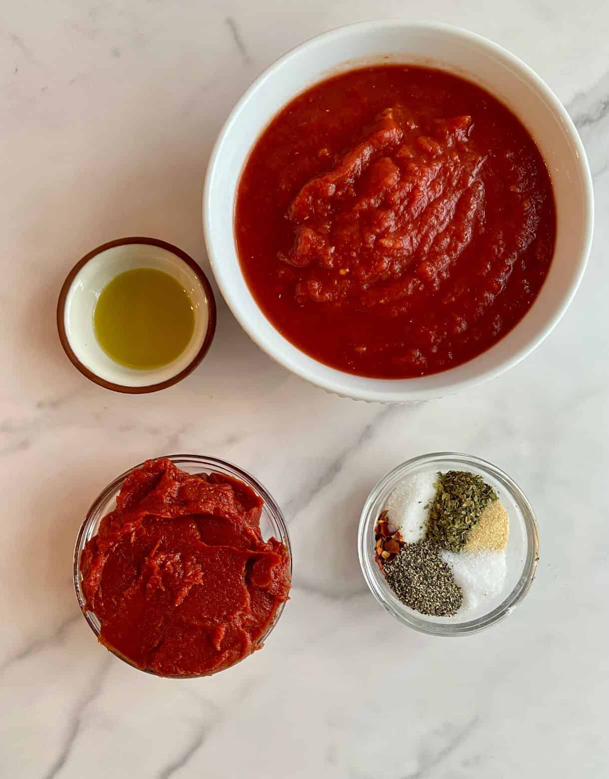 Ingredients for Easy Marinara Sauce. Crushed tomatoes, tomato paste, olive oil, sugar, Italian seasoning, salt, garlic powder, red pepper flakes and black pepper.