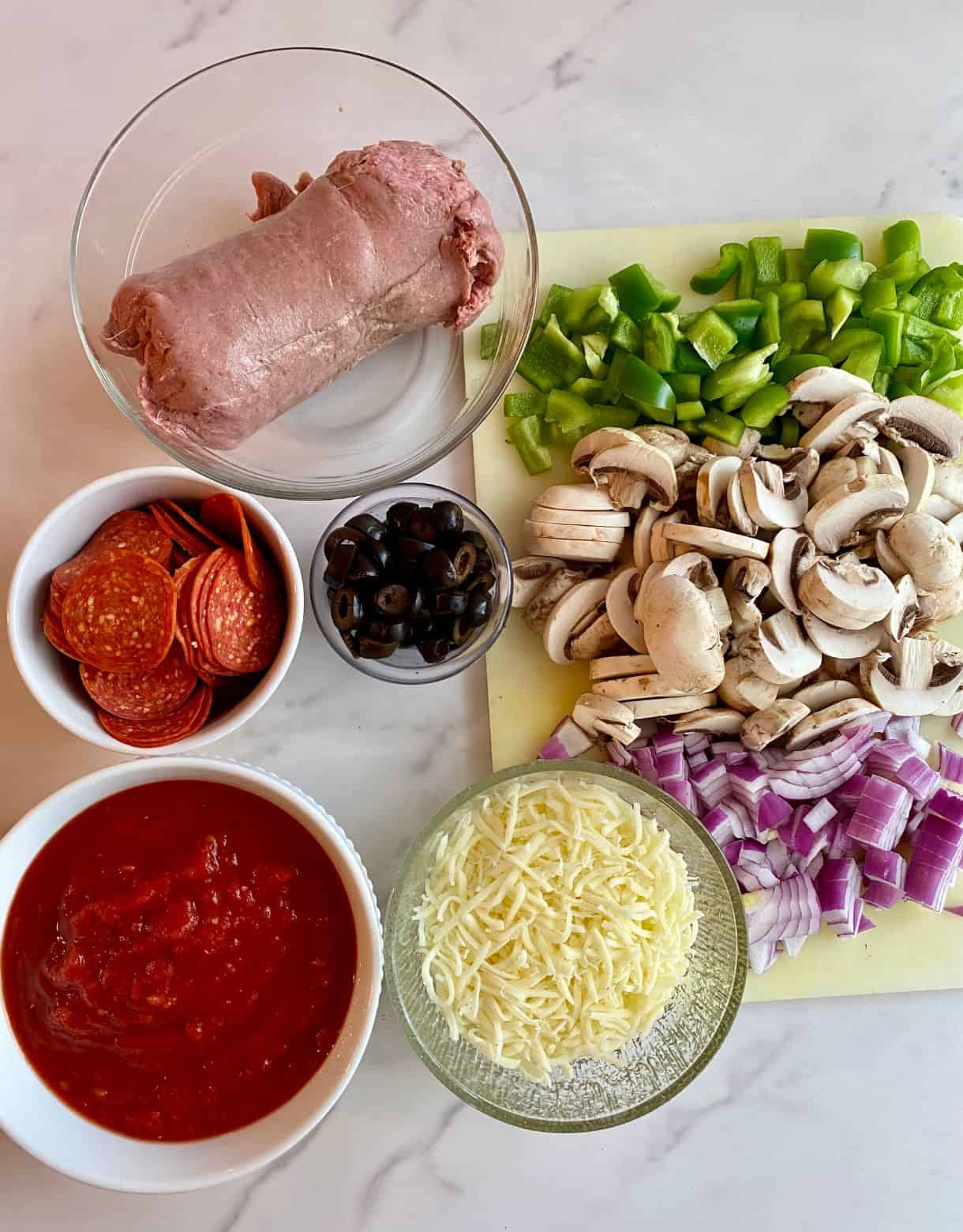 Ingredients for Pizza Bowls. Turkey sausage, pepperoni, marinara sauce, shredded mozzarella cheese, black olives, chopped onion, chopped bell pepper and sliced mushrooms.