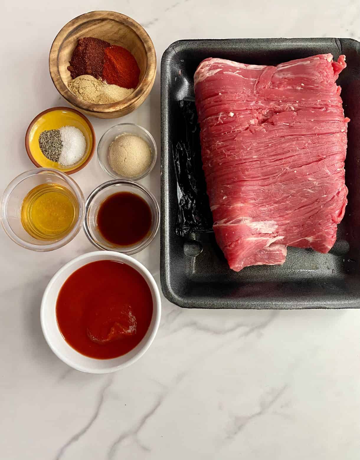 Ingredients for Pulled Beef Tacos. Flank steak, tomato sauce, hot sauce, applie cider vinegar, brown sugar, salt, pepper and other spices.
