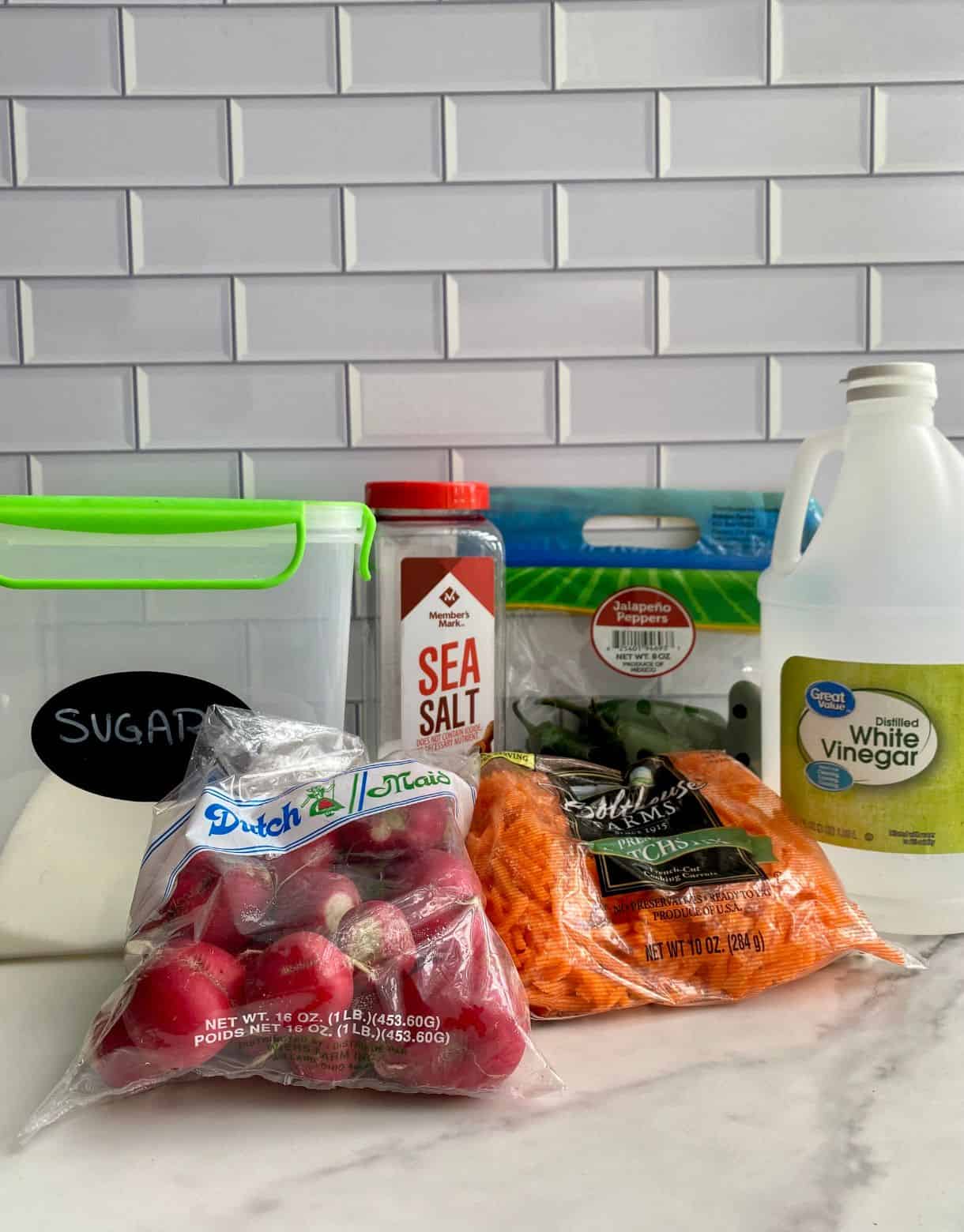 Vinegar, sugar, salt, jalapenos, radishes and a bag of shredded carrots.