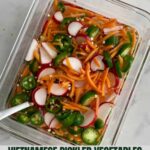 A container of Vietnamese Pickled Vegetables with sliced jalapenos, sliced radishes and shredded carrots floating in vinegar with the Healthy Mom Healthy Family logo.