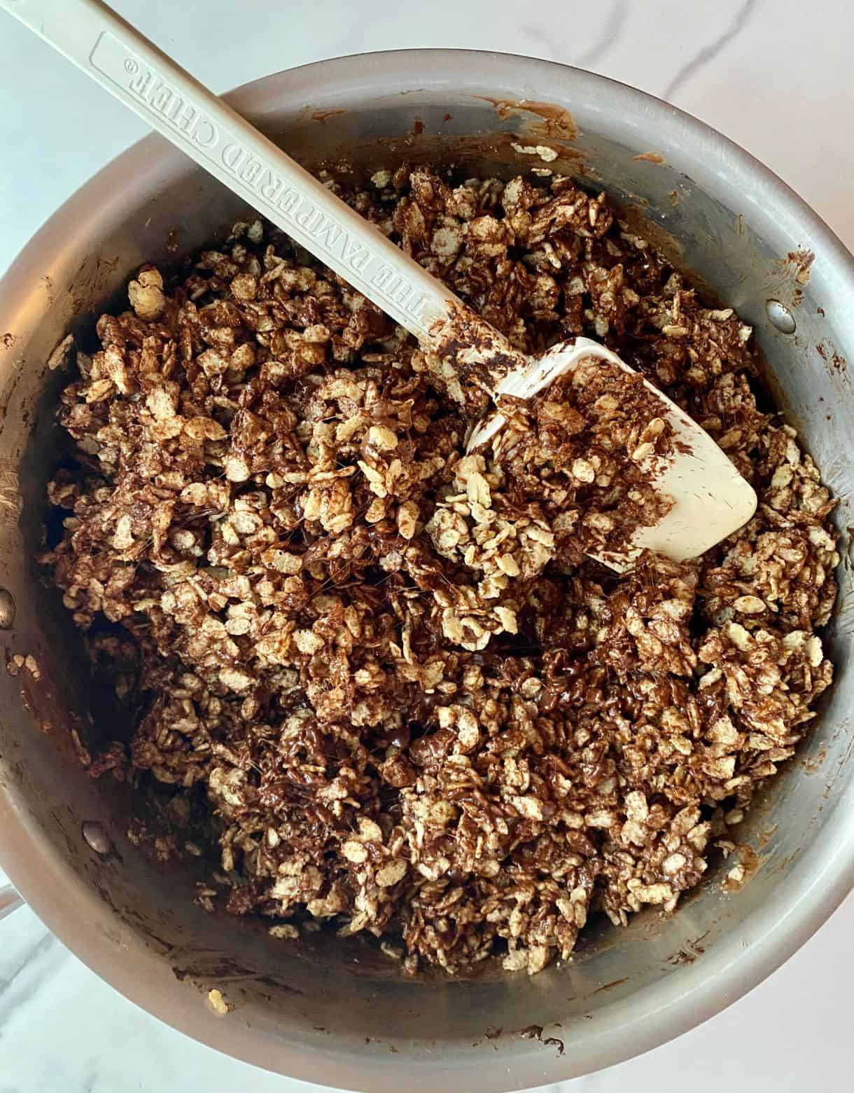 A pot of Chocolate Rice Krispie Treats mixed up and ready to spread into a dish.