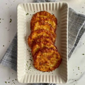 A serving plate with baked cheese chips.