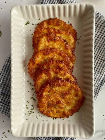 A serving plate with baked cheese chips.