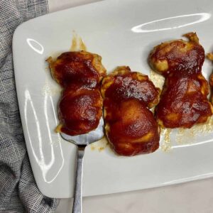 A platter with cooked Baked BBQ Chicken Thighs.