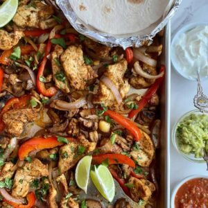 A sheet pan with cooked Chicken Fajita Tray Bake.