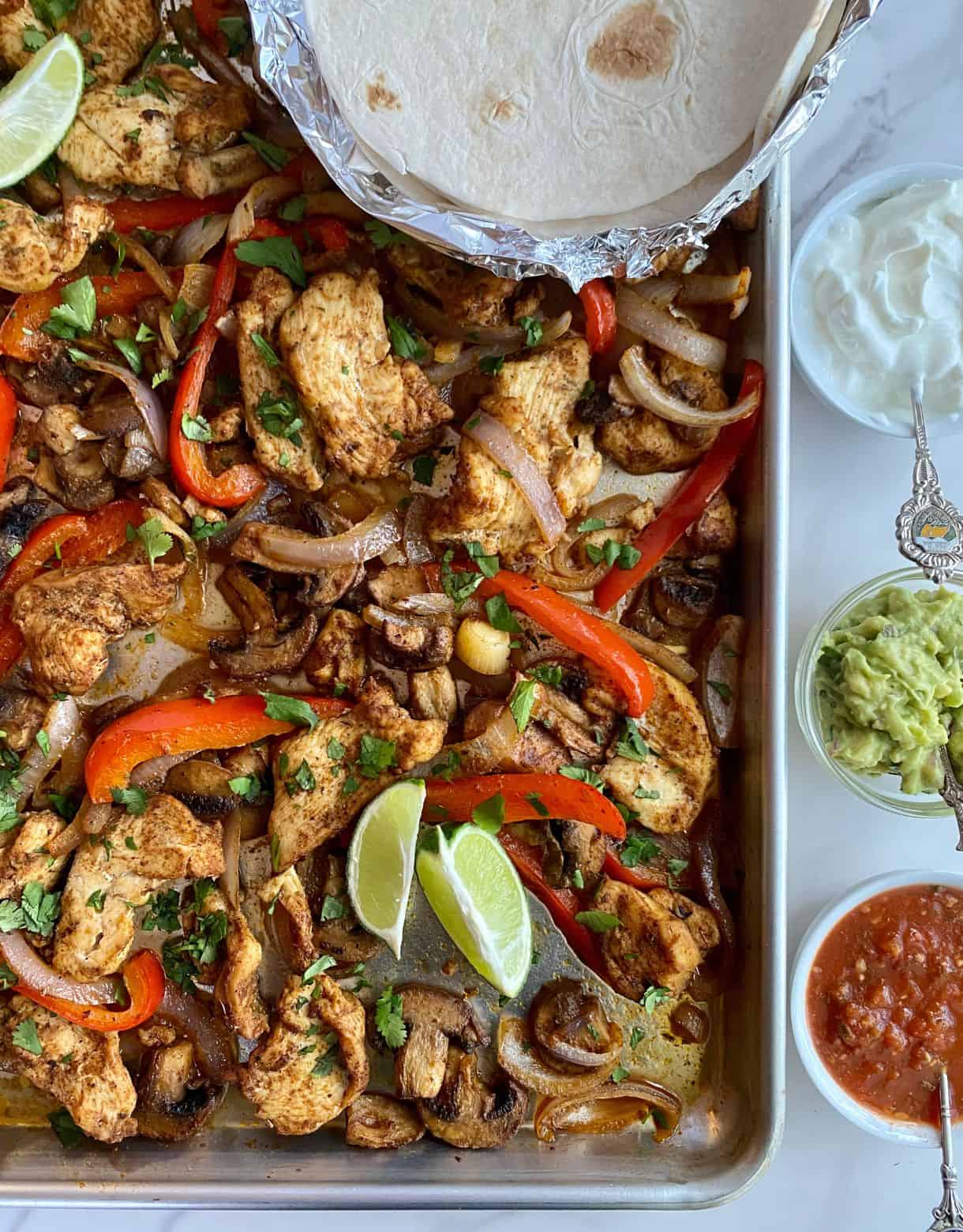 A sheet pan with cooked Chicken Fajita Tray Bake.
