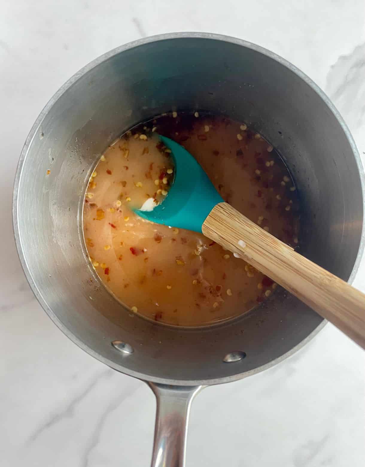 A pot with sweet chili sauce after adding the cornstarch.