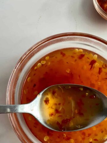 A bowl of Sweet Chili Sauce with a spoon.
