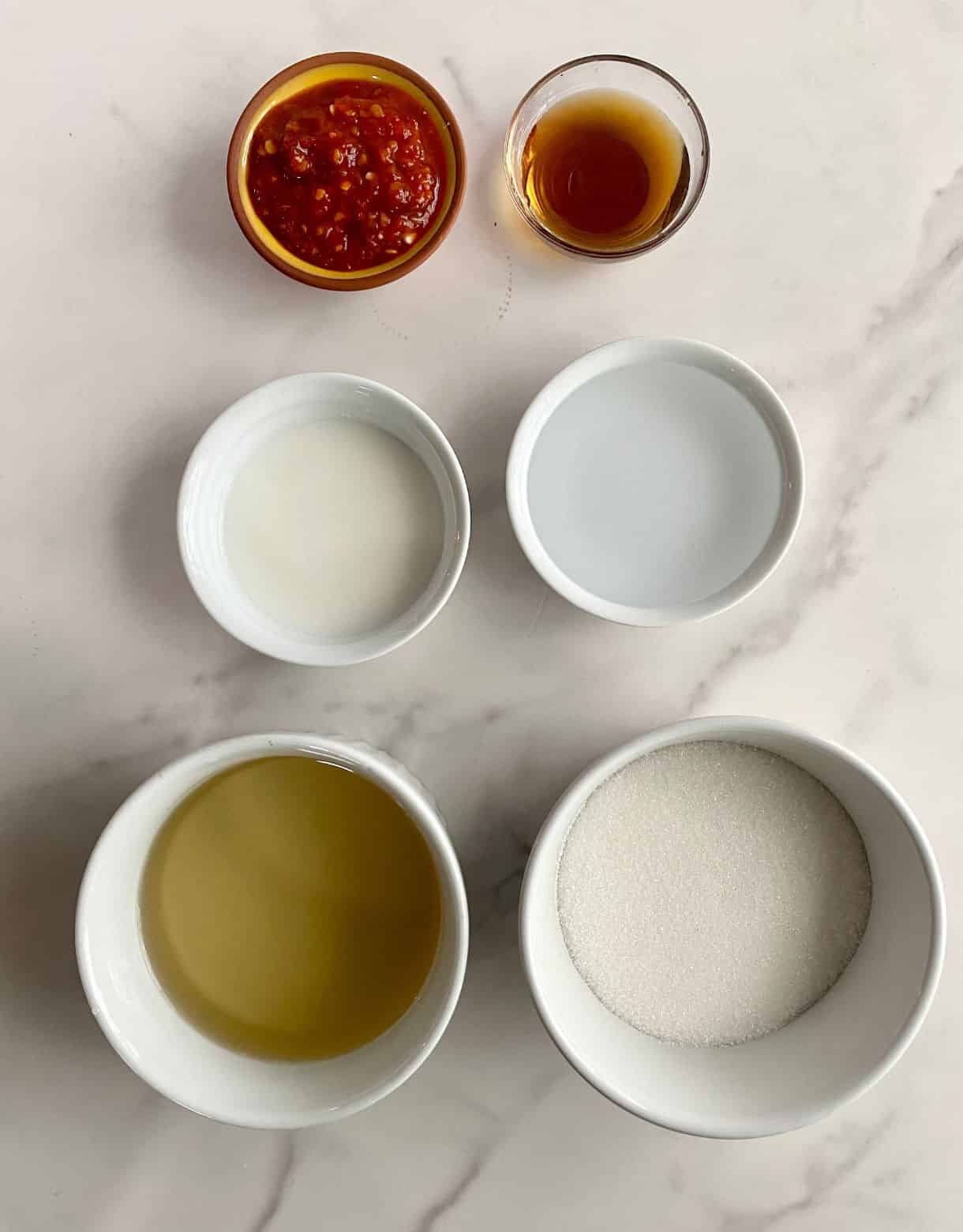 Small bowls or sugar, rice vinegar, water, cornstarch, fish sauce and chili garlic sauce.