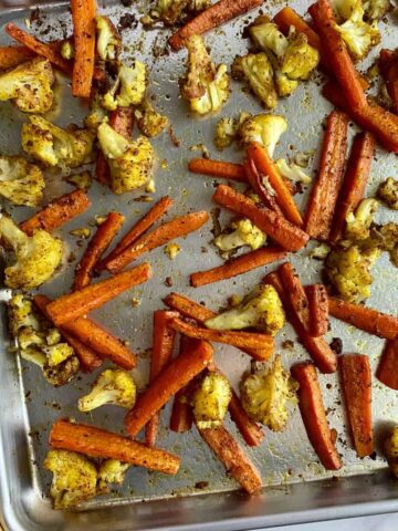 A sheet pan with roasted cauliflower and carrots.