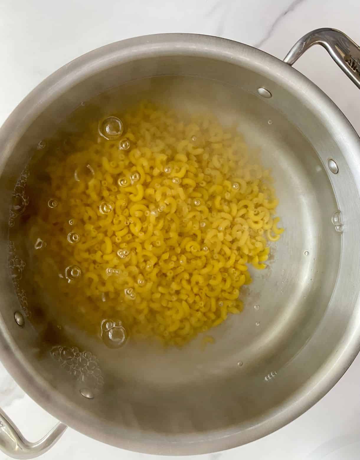 A pot of water with pasta boiling.