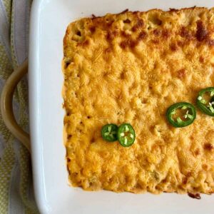 A pan of macaroni and cheese topped with jalapenos.