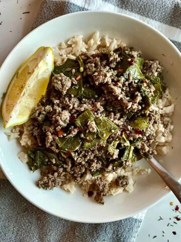 A Lebanese Grape Leaves Bowl with a wedge of lemon.