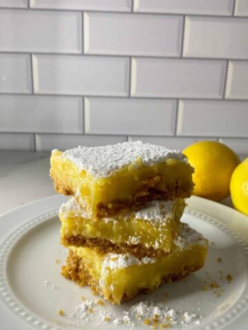 A stack of 3 lemon bars with a graham cracker crust.