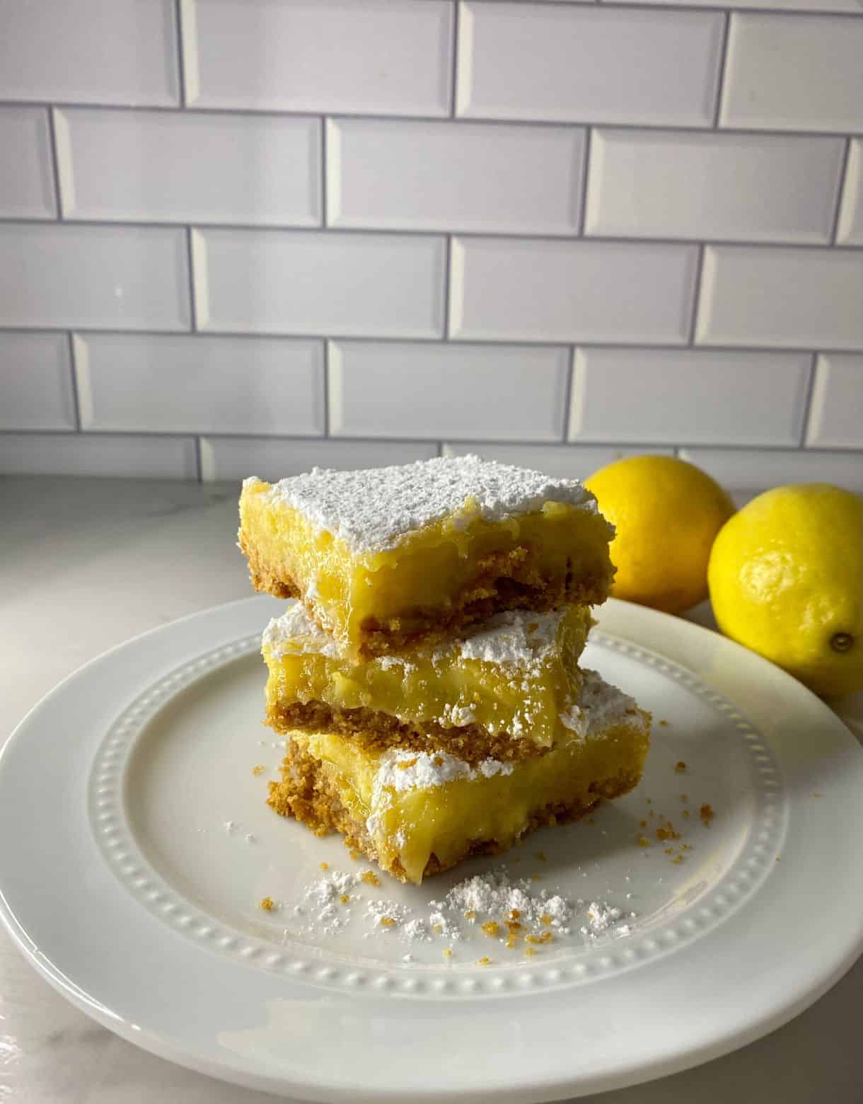 A stack of 3 lemon bars with a graham cracker crust.