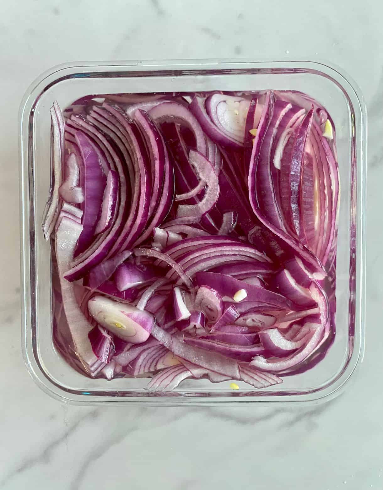 A glass dish with Mexican Pickled Onions marinating.