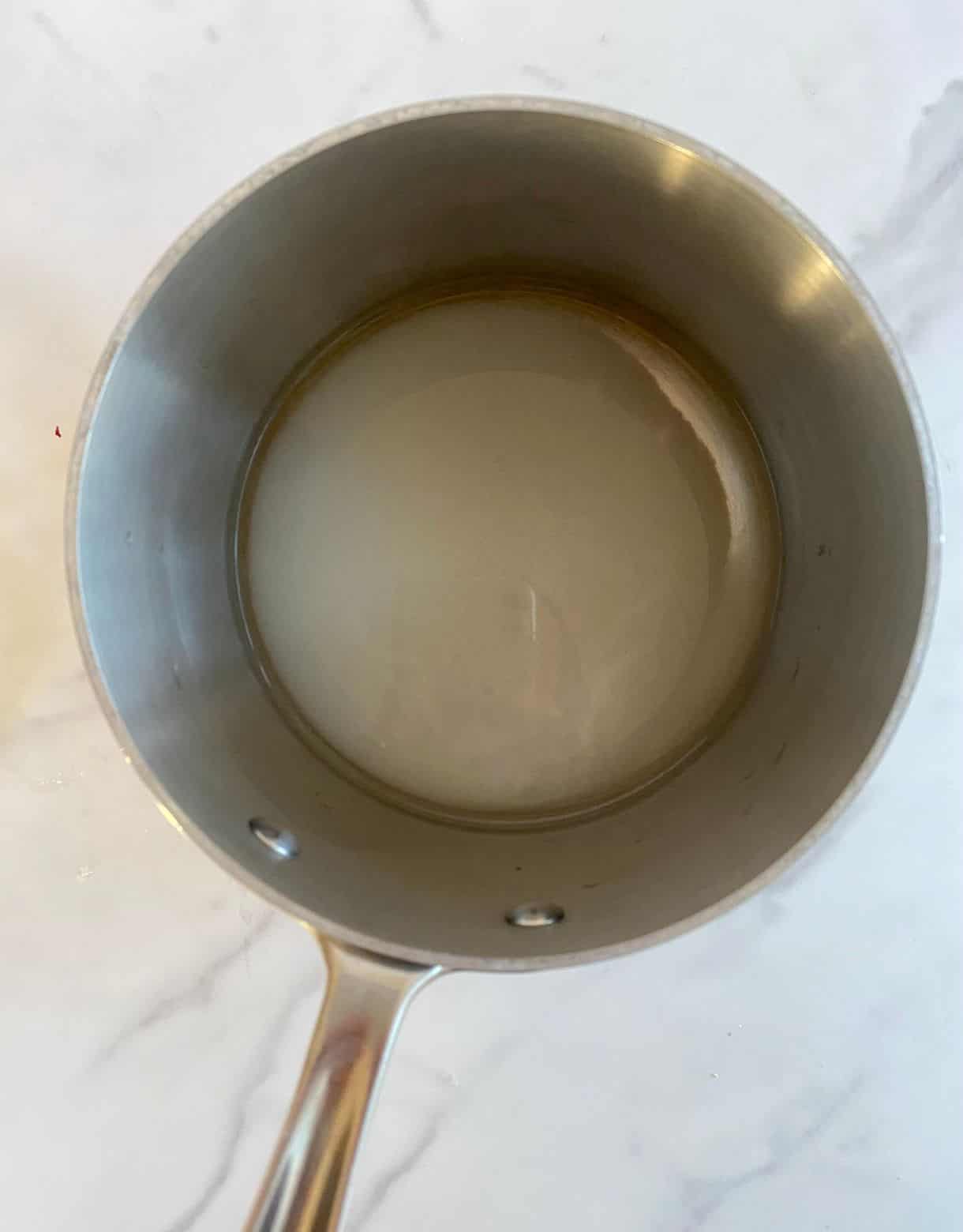 A small pot with vinegar, sugar and salt added to it.