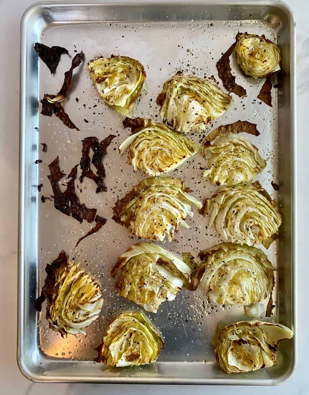 A sheet pan with cooked Oven Roasted Cabbage Steaks.