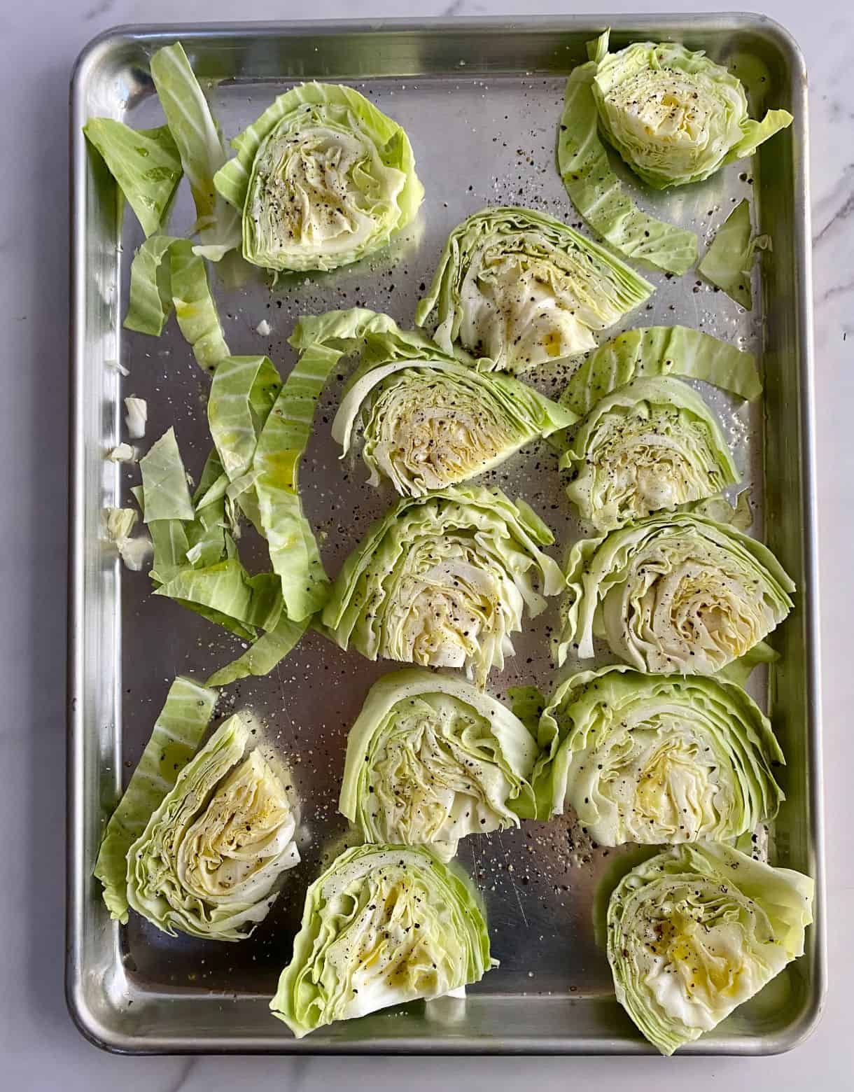 A sheet pan with slices of cabbage on it but not yet baked.