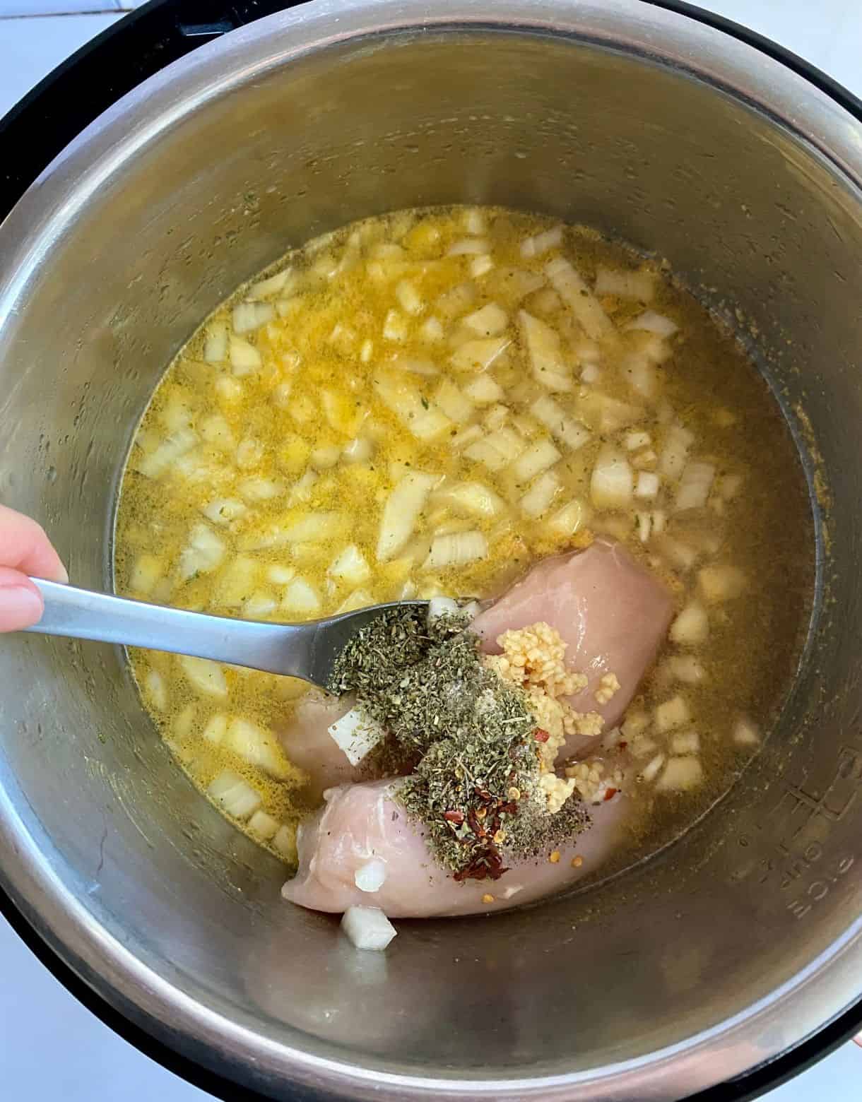 A slow cooker with the ingredients for Chicken Kale Soup added but not stirred.