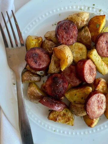 A plate of oven roasted smoked sausage and potatoes.