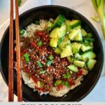 A Bulgogi Bowl with seasoned beef served over cauliflower rice and topped with sliced green onions, sesame seeds, pickled cucumbers and sriracha sauce.