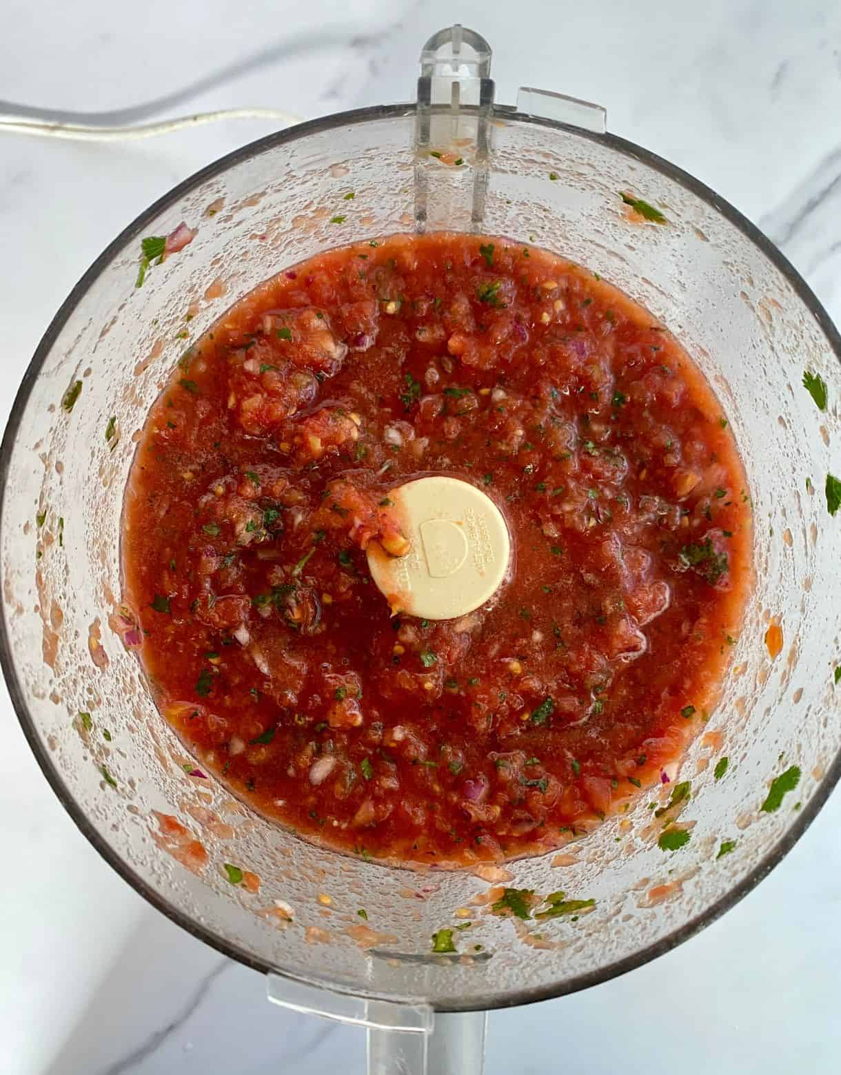 A food processor with finished Jalapeno Salsa.