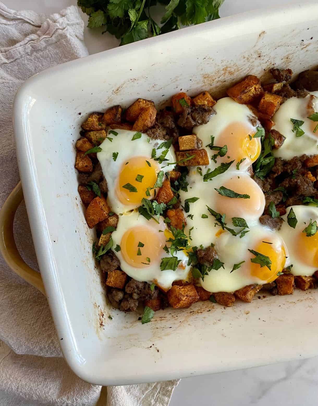 A pan of cooked Sweet Potato Breakfast Hash with sausage, sweet potatoes and eggs.