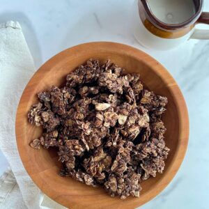 A bowl of Dark Chocolate Granola and a pitcher of almond milk.