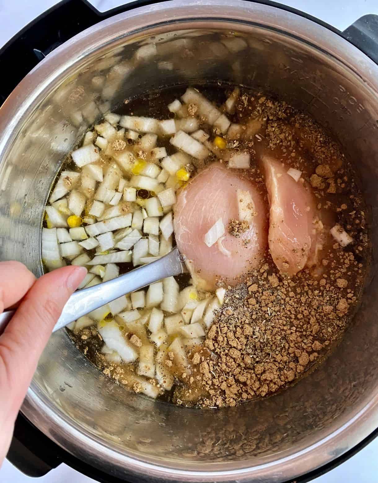 A slow cooker with the ingredients added for Green Chile Chicken Soup but not yet stirred.