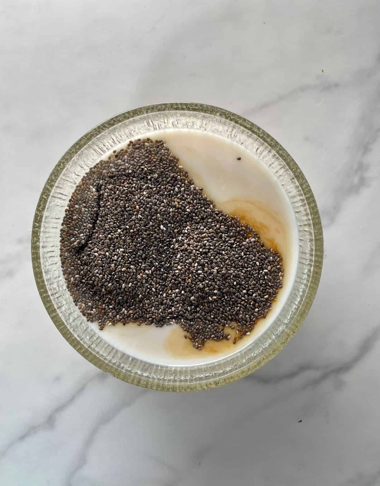 A bowl with the ingredients added for Keto Chia Pudding but not yet mixed.