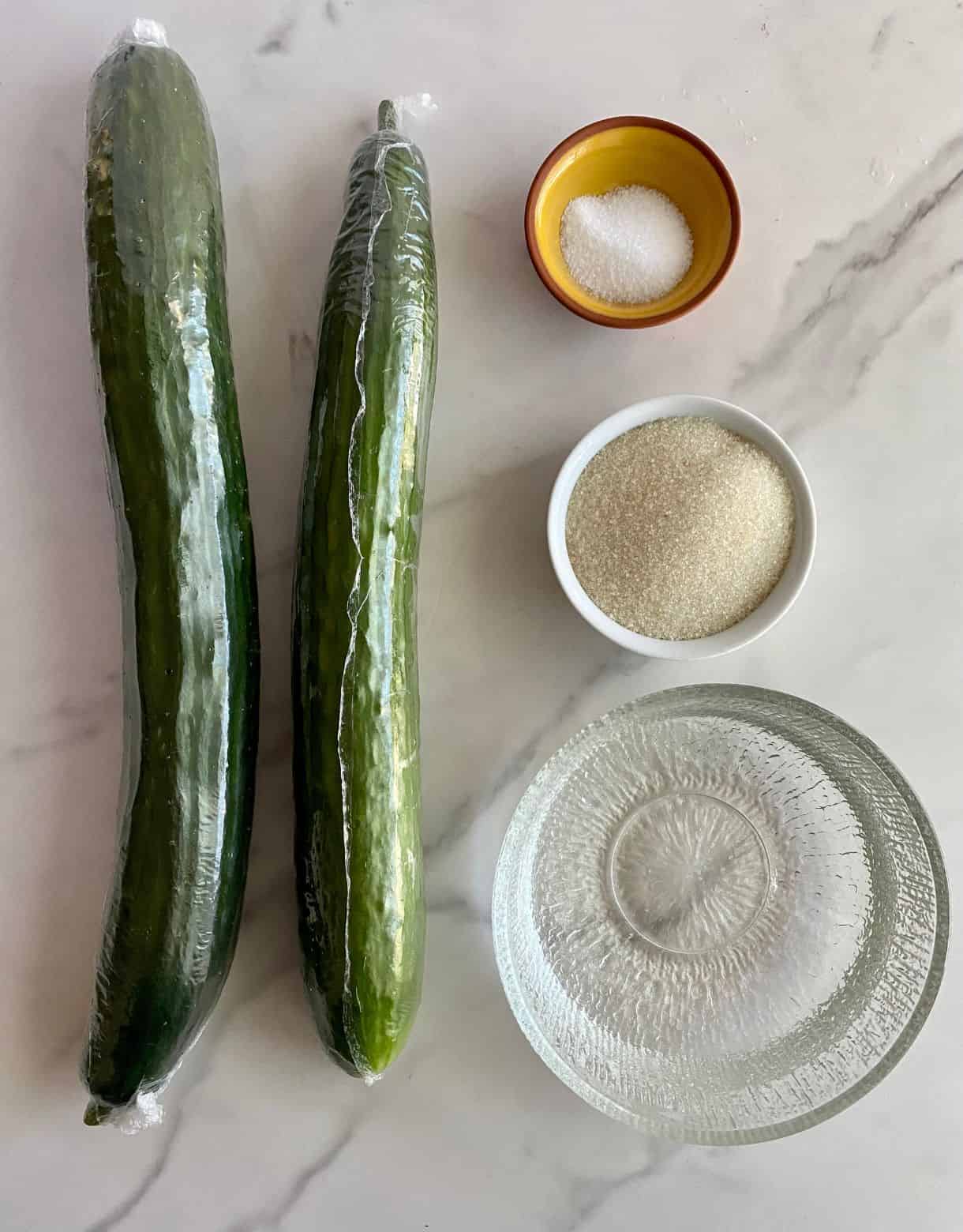 Ingredients for Pickled Cucumbers. White vinegar, salt, sugar and two english cucumbers.