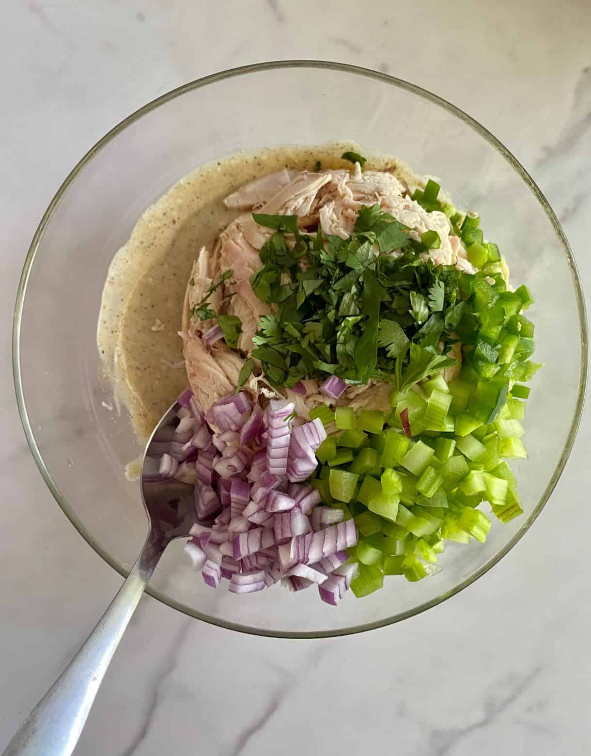 A bowl with the ingredients for Guacamole Chicken Salad added but not yet mixed.