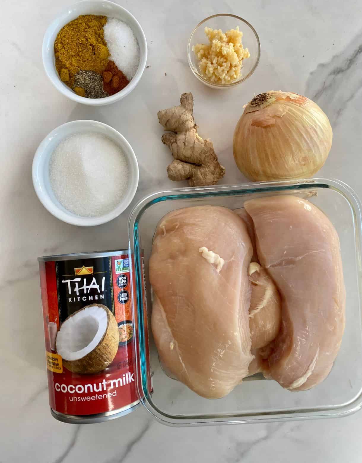 Ingredients for Slow Cooker Curry Chicken. Chicken breasts, a can of coconut milk, onion ginger, garlic, sugar, salt, pepper, curry powder and cayenne.