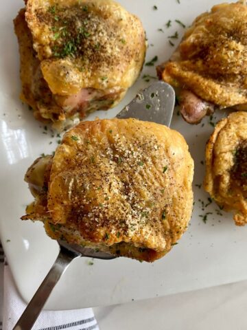 A platter with 4 cooked Southern Baked Chicken Thighs.