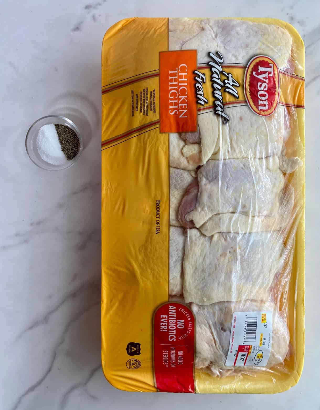 A package of chicken thighs, salt and pepper.