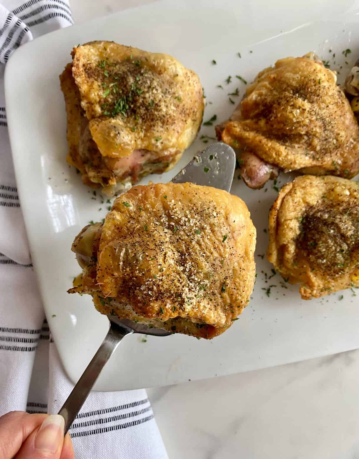 A platter with 4 cooked Southern Baked Chicken Thighs.