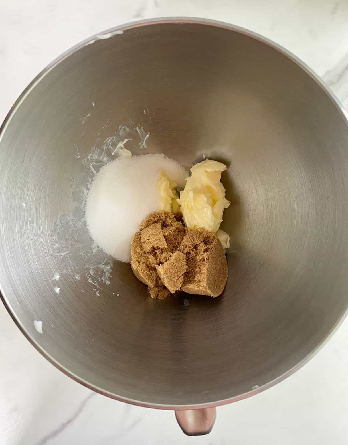 A bowl with butter, sugar and brown sugar.