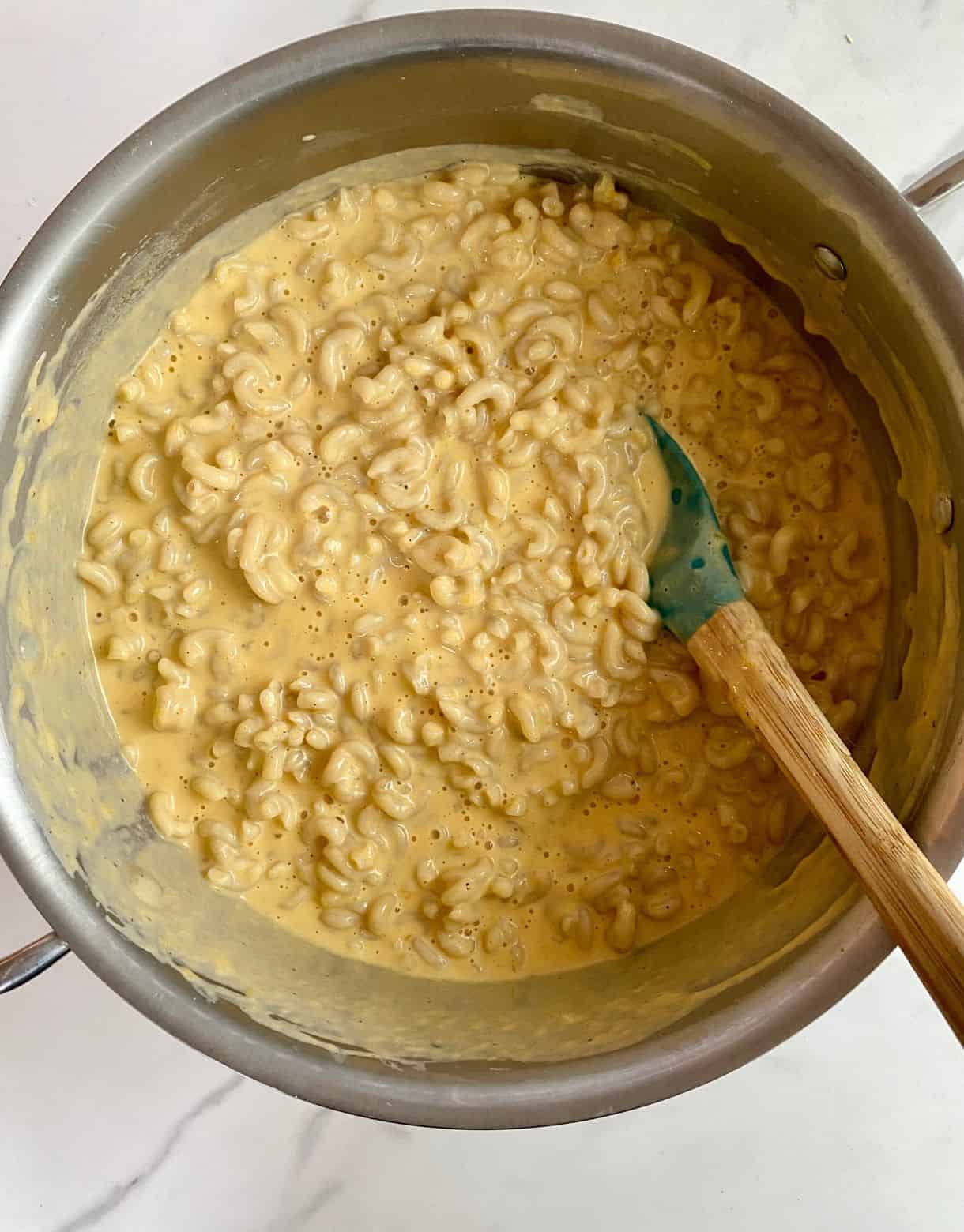 A pot of cheese sauce with pasta added.