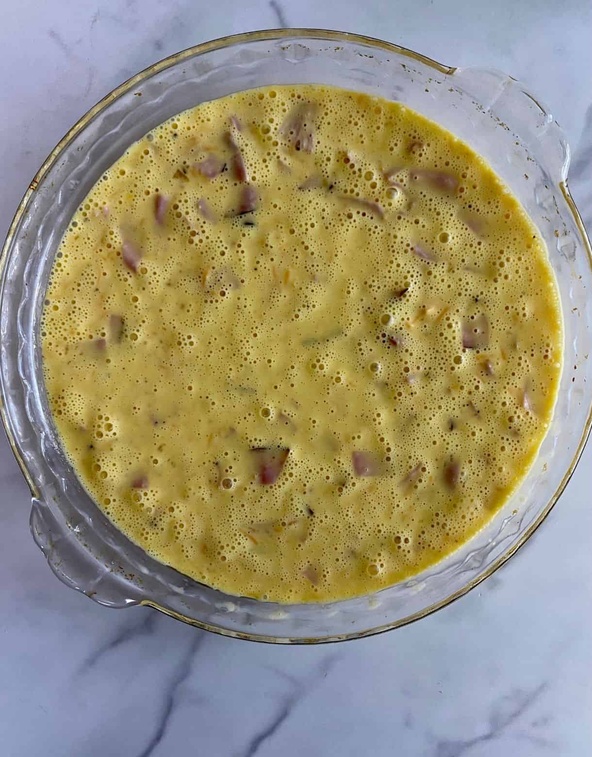 An unbaked Ham and Cheese Crustless Quiche.