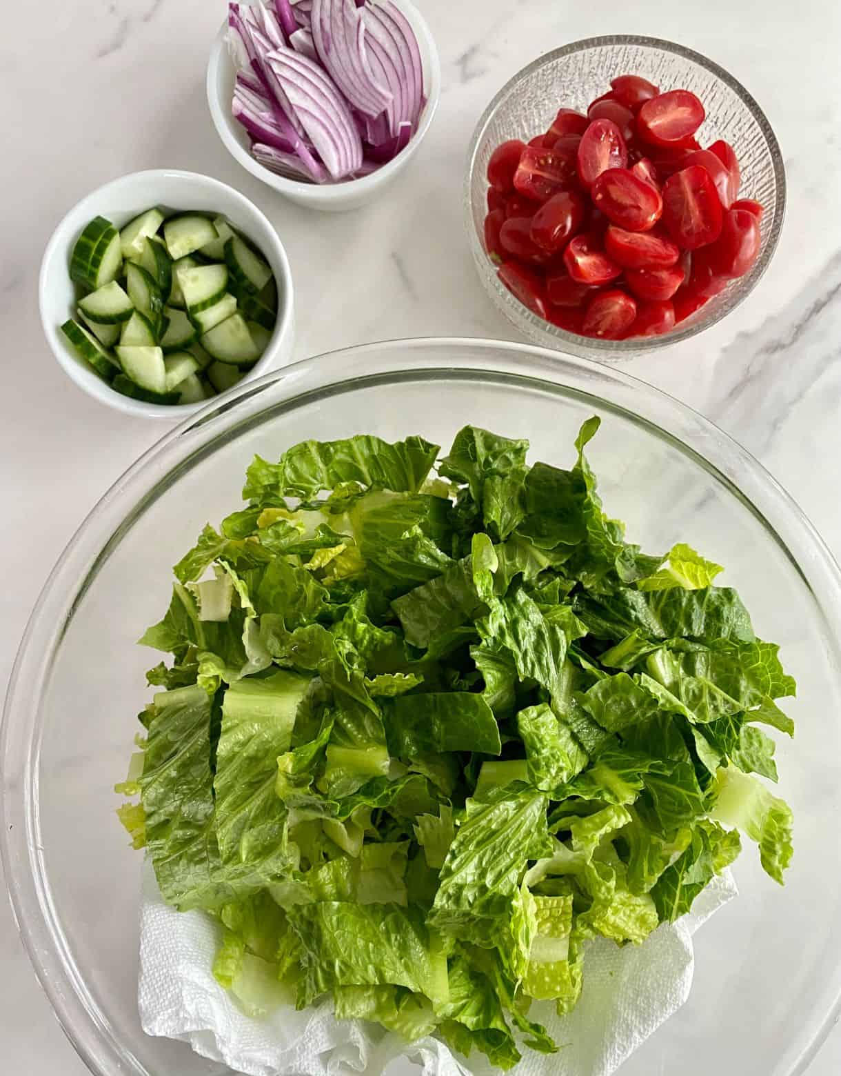 Chopped romaine lettuce, chopped cucumber, sliced red onion and halved grape tomatoes.
