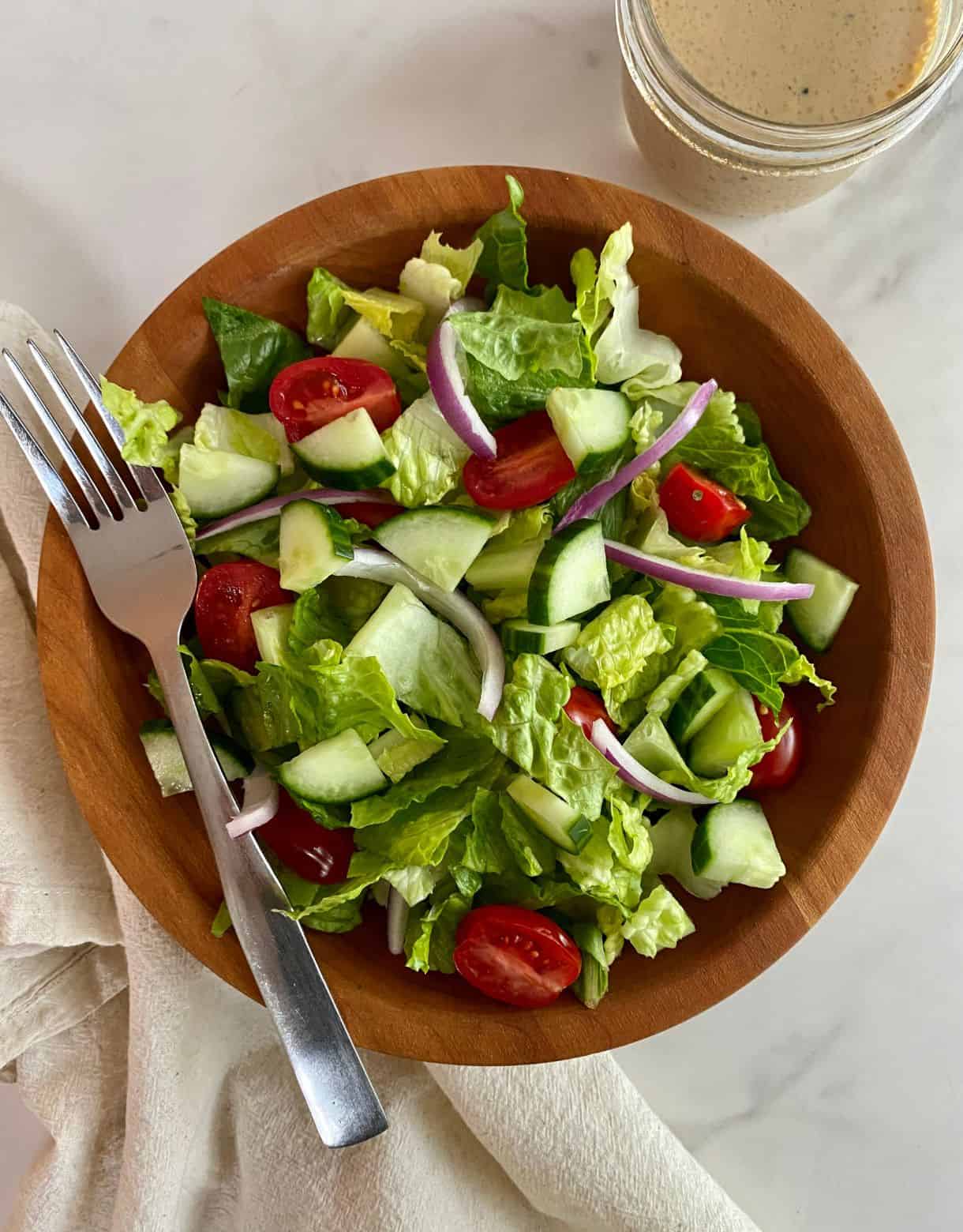 A House Salad with a jar of Red Wine Vinaigrette.