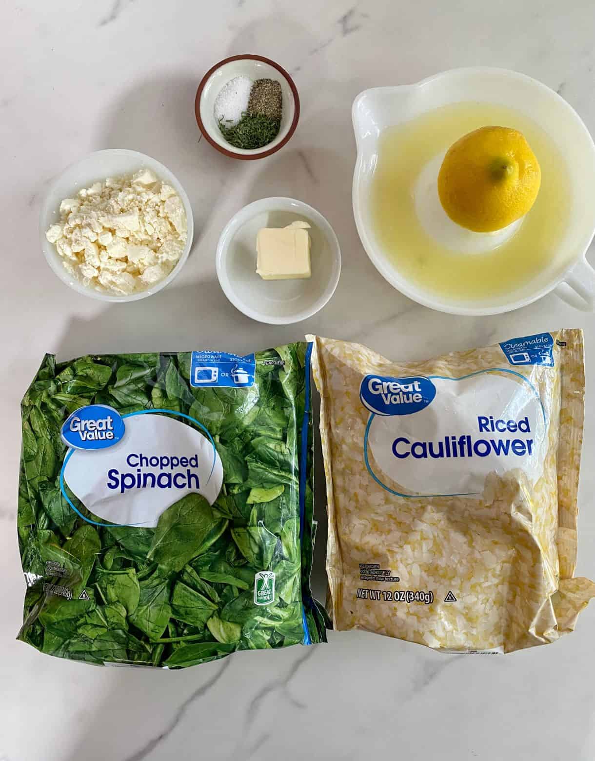 A bag of frozen spinach, a bag of frozen cauliflower rice, lemon juice, feta cheese, salt, pepper, dill and butter.