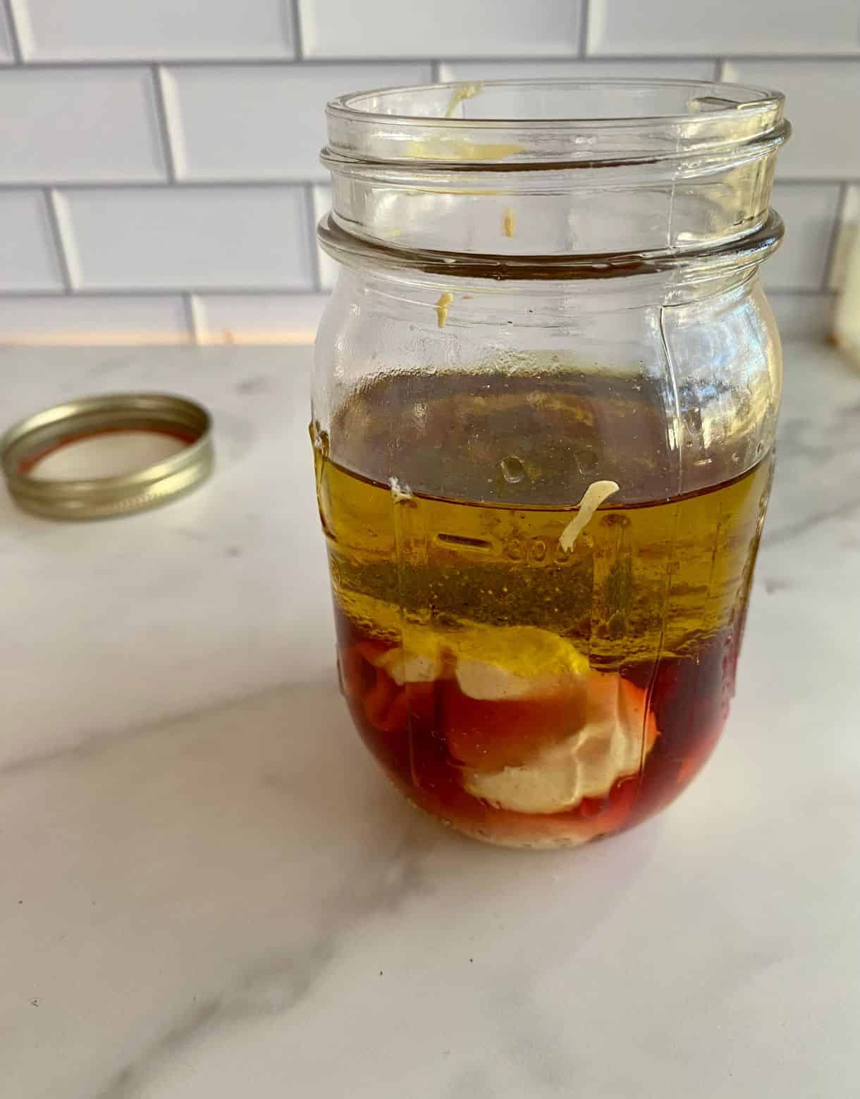 A jar with ingredients added but not yet mixed for Red Wine Vinairgette.