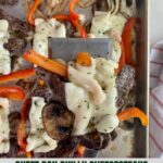 A sheet pan with cooked Philly Cheesesteaks.